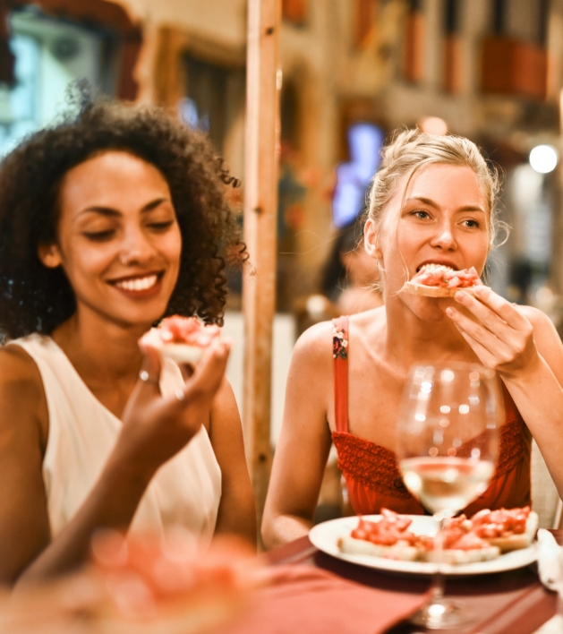 Two women eating in a food hall environment